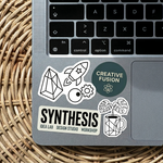 Laptop with custom stickers featuring geometric shapes, rocket illustration, “Creative Fusion” circle, plant and mug icons, and “SYNTHESIS Idea Lab Design Studio Workshop” text