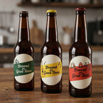 Three beer bottles with branded 'Brewed for Good Times' labels on a wooden surface.