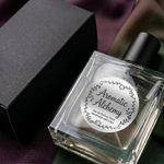 Durable silver foil labels perfectly applied on curved glass perfume bottles, demonstrating waterproof silver stickers that grip seamlessly to smooth surfaces.