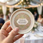 Hand holding a decorative coaster with personalized stickers at wedding.