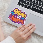 macbook keyboard decal with a 'Make it happen' sticker on a fluffy surface