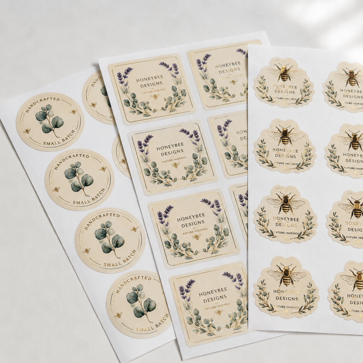Multiple sheets of custom 2-inch labels featuring vintage-style botanical and honeybee designs. These 2-inch round and square stickers showcase high-quality printing for small batch branding.