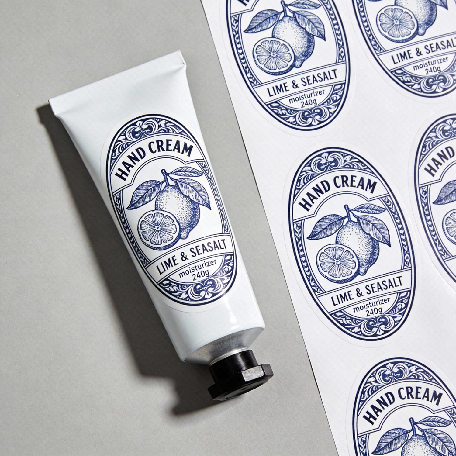 Oval sheet labels for hand cream packaging, featuring blue botanical Lime and Seasalt stickers on a cosmetic tube and label sheet