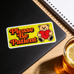 Laptop with custom sticker featuring “Please Be Patient” text and teddy bear illustration