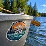 UV resistant stickers featuring a compass and ocean design applied to the exterior of a boat on a lake.