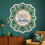 Stunning wall art stickers large mandala leaf pattern reading "Create the Adventure" on a dark teal living room wall.