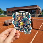 An athletic club stickers design with a lion and tennis rackets graphic, displayed at a red clay tennis court.