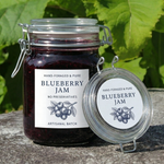 Jar of blueberry jam with a label on a natural background