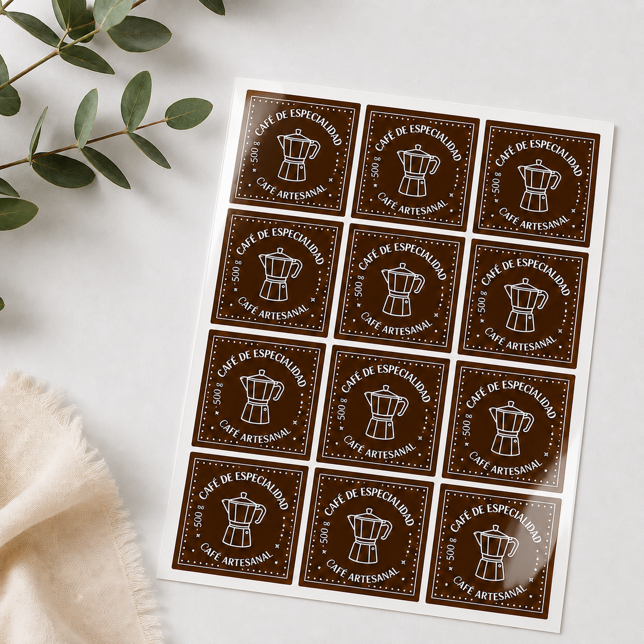 Brown square sheet labels for coffee packaging arranged on a glossy label sheet