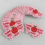 Stack of cute Thank You Very Berry Much handmade stickers featuring a smiling apple design on a light background.