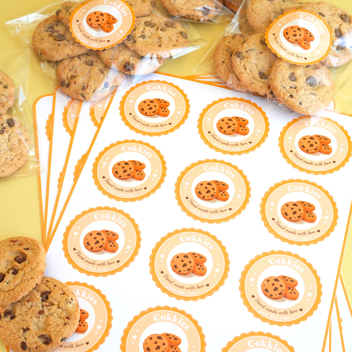 Custom stickers featuring chocolate chip cookie designs on round sticker sheets and packaged cookie bags.