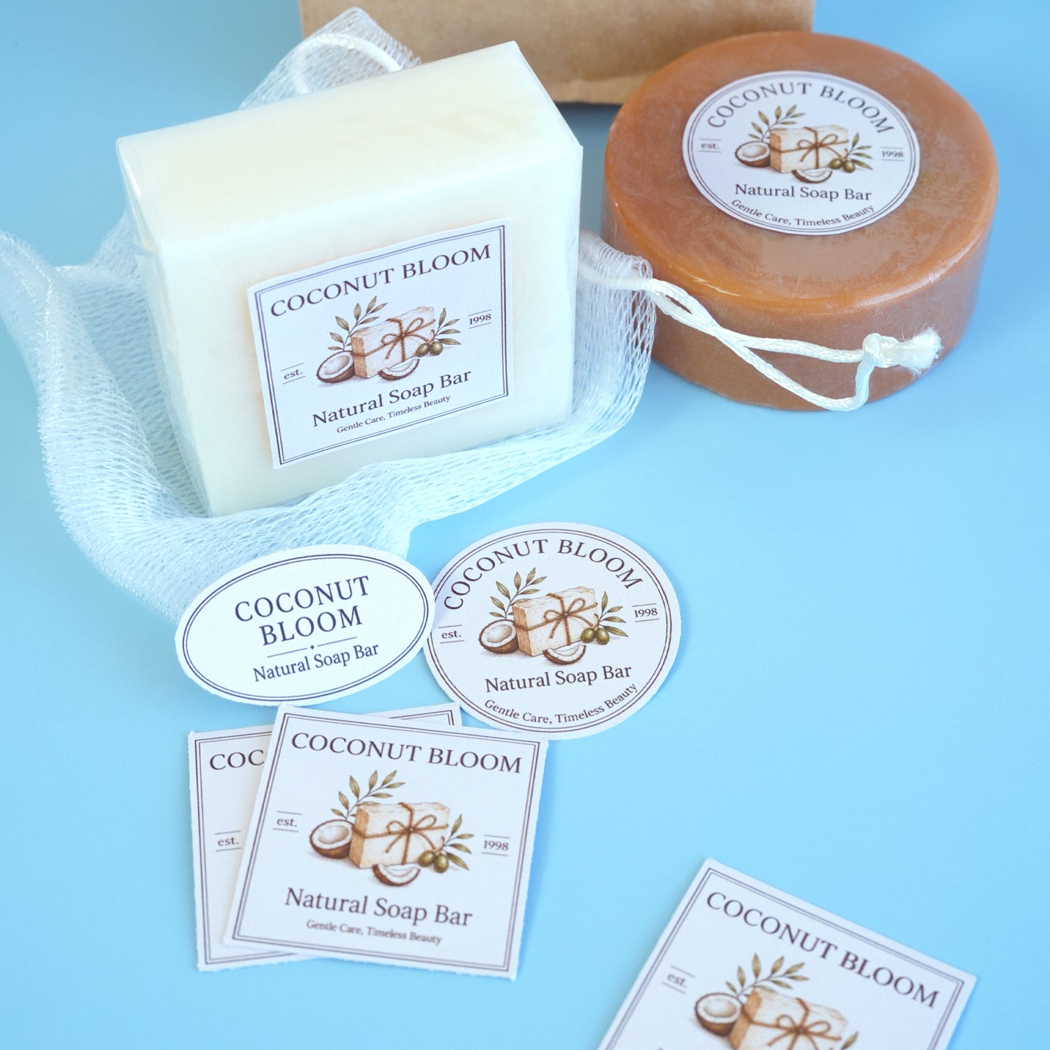Custom branding stickers and labels for Coconut Bloom natural soap bars and packaging on a blue background.