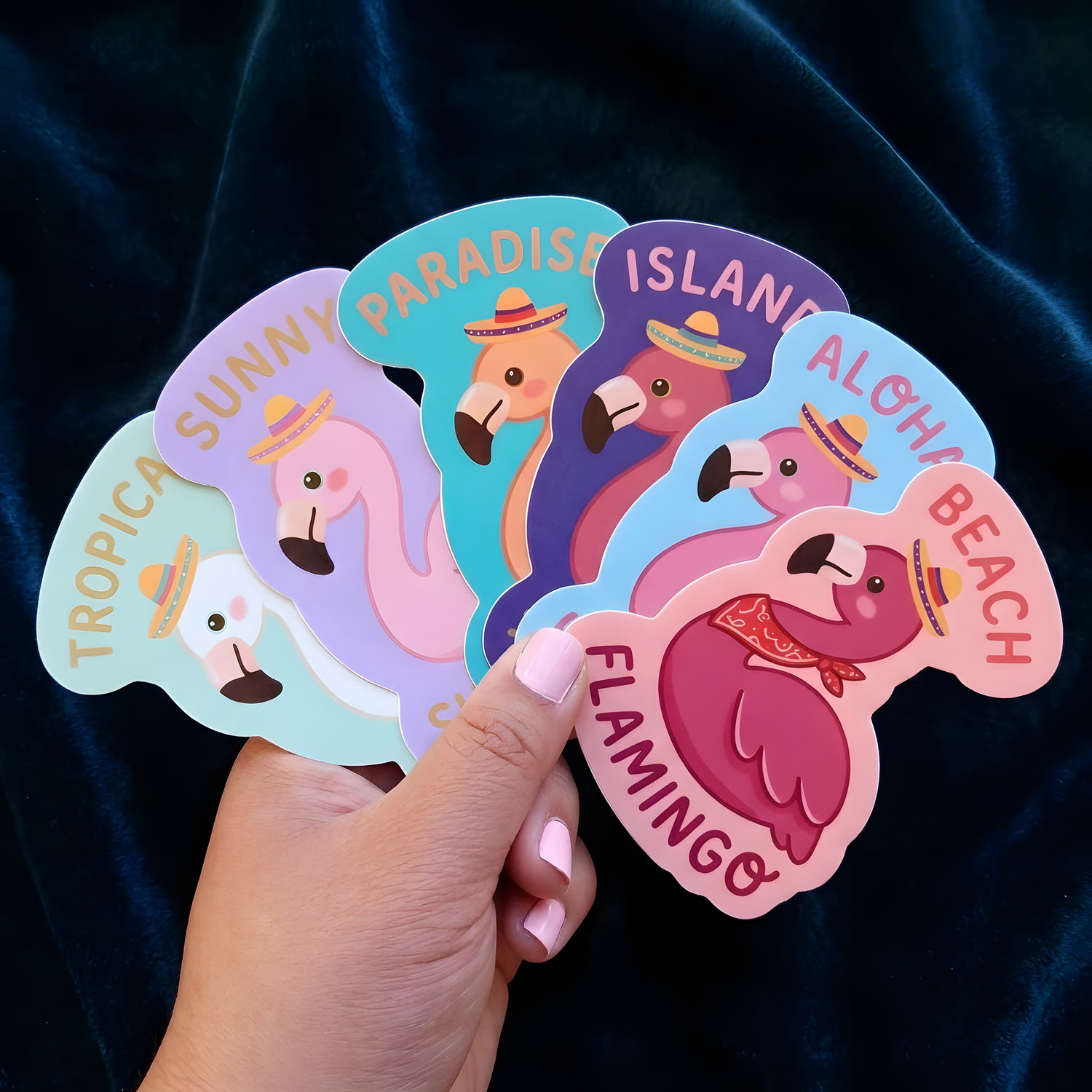 Hand holding colorful custom flamingo vinyl stickers with tropical designs