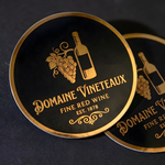 Custom round black and gold metallic stickers featuring a premium wine brand design.