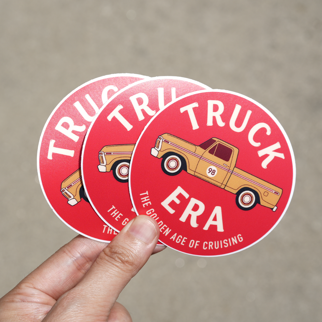 Hand holding three red custom circle stickers featuring a vintage truck logo design.