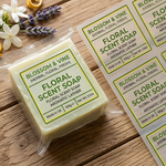 Custom clear product labels on packaged floral soap with additional labels shown on a sheet.
