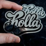 Hand holding a custom die-cut silver metallic sticker with a black script logo.