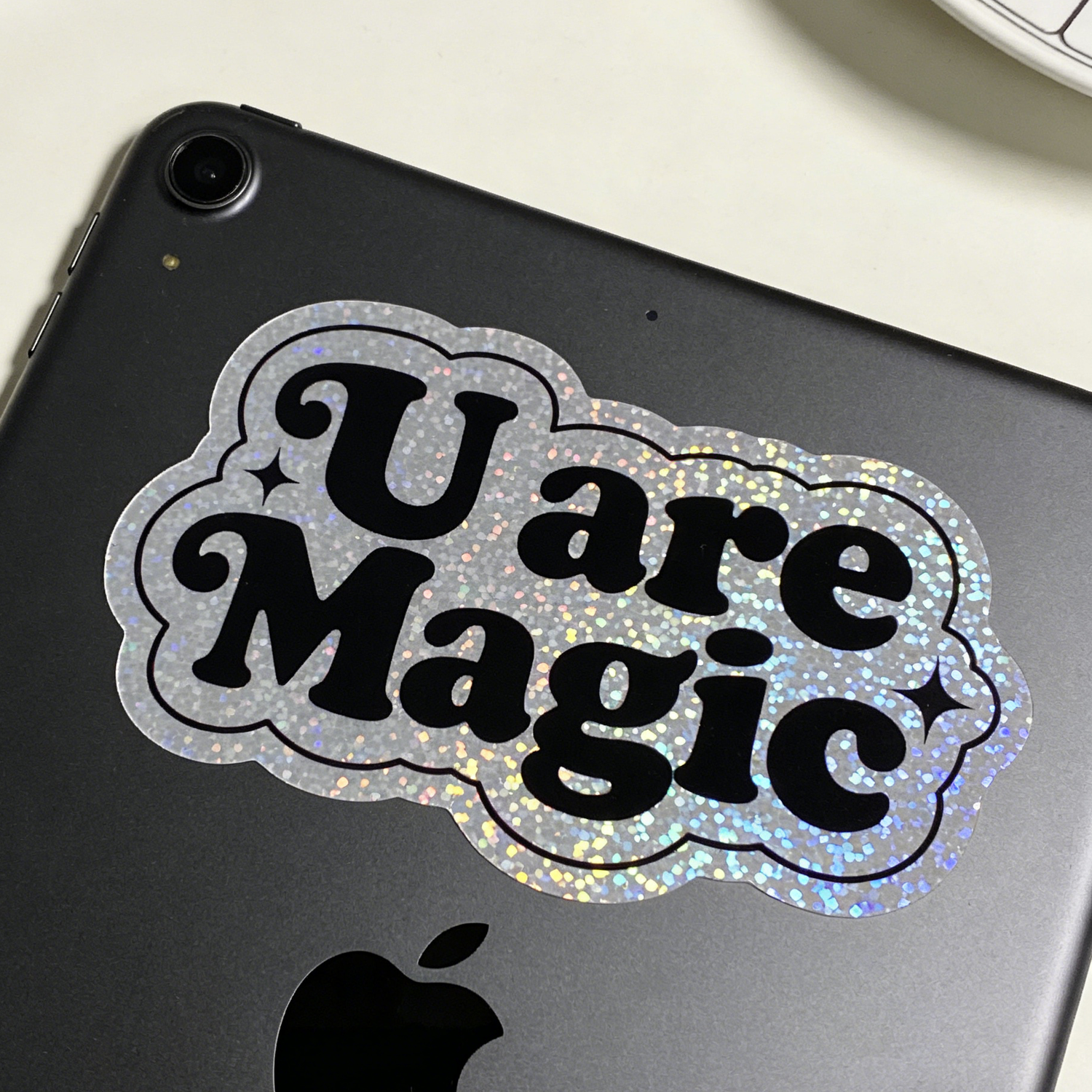 Glitter sticker with design of 'U are Magic' sticker on a black tablet device
