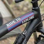 Custom heavy duty sticker with a colorful Ride to Explore design applied to a black mountain bike frame.