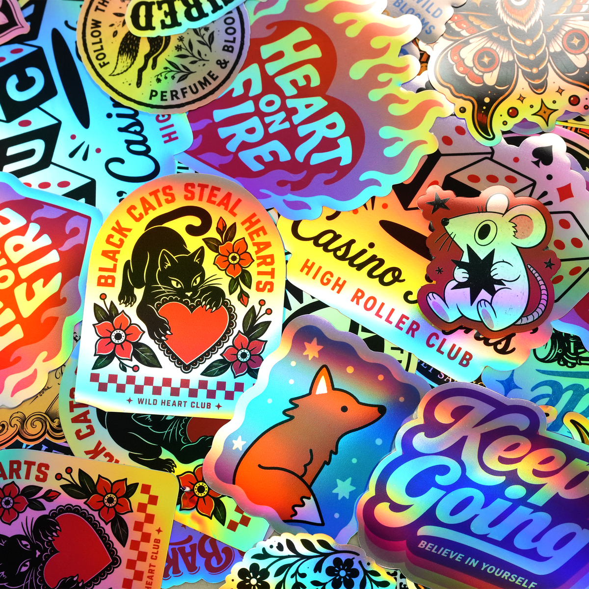 Assorted custom holographic stickers with colorful designs and rainbow reflective effects.