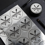 Custom metallic silver labels shown on a brow pomade container and matching round label sheets.