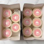 Paper bags filled with Crèmerie Pudding containers featuring custom pink logo stickers.