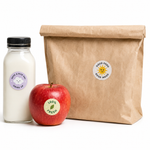 Custom 1 inch round stickers used as packaging labels on a brown paper bag, a glass milk bottle, and a fresh apple to demonstrate versatile labeling.