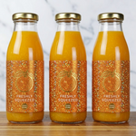 Three glass bottles of fresh orange juice with custom orange glitter labels, showcasing waterproof glitter labels for cold beverages and juice packaging.