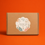 A die-cut scalloped circle packaging sticker with cosmetic illustrations and 'Thank You' text on a mailer box.