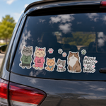 A custom cat family auto sticker on a rear car window with cute cartoon cats dressed as cat dad and cat mom next to Meow Family on Board text.