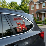 Car window with a red cat decal and text 'Purr-fectly Mischievous' in a residential area.