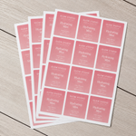Multiple sheets of square pink 'Glow Studio Hydrating Mist' skincare stickers stacked on a wooden surface, showing bulk custom label printing.