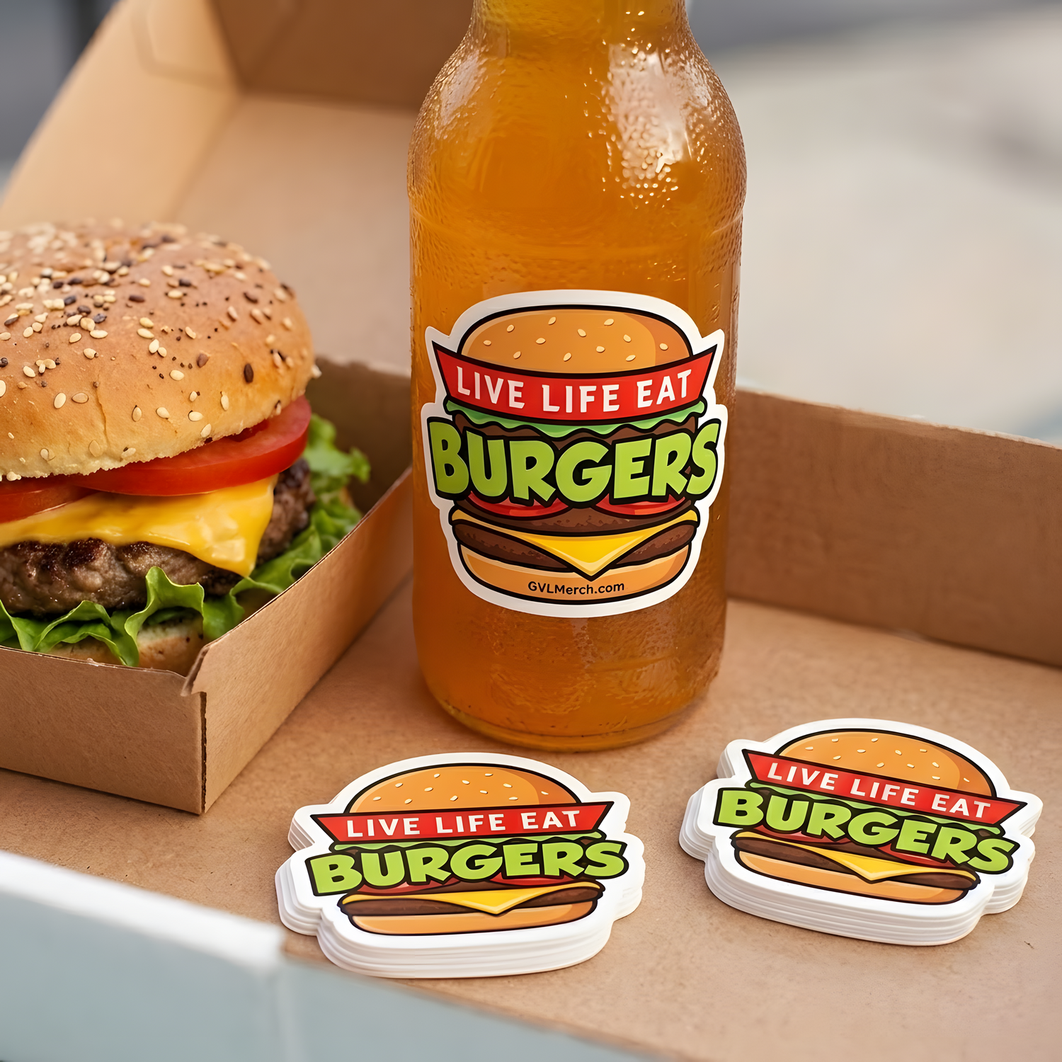 Live Life Eat Burgers custom stickers applied to a beverage bottle next to burger stacks in a takeaway box.