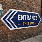 Large outdoor decal with an entrance arrow design applied to a red brick wall for directional signage.