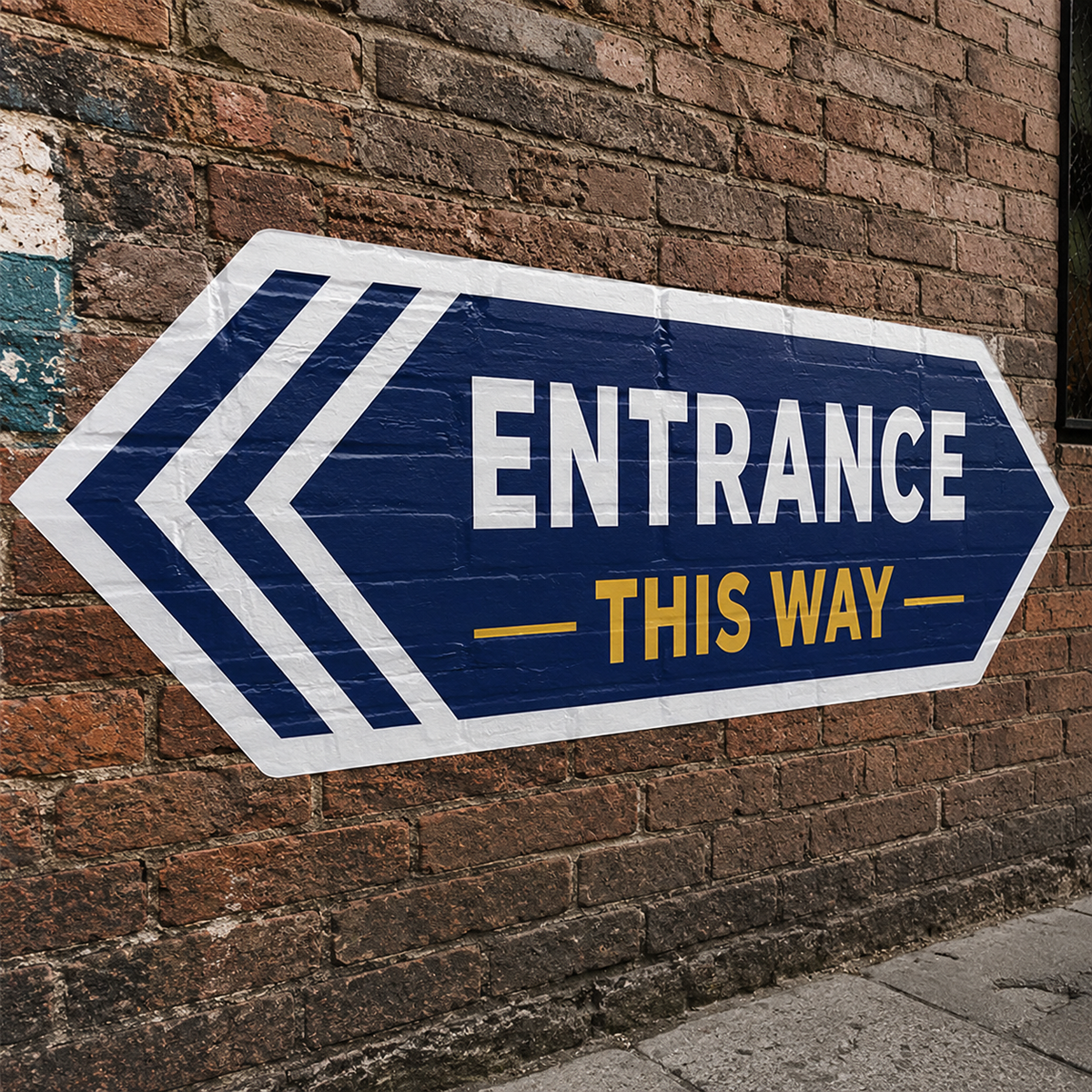 Large outdoor decal with an entrance arrow design applied to a red brick wall for directional signage.
