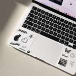 macbook air computer with black keyboard and various stickers on a beige surface, no minimum order