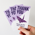 Professional matte stickers used for product branding on "Thank You For Your Support" cards, featuring a purple origami crane design and clean minimalist typography.