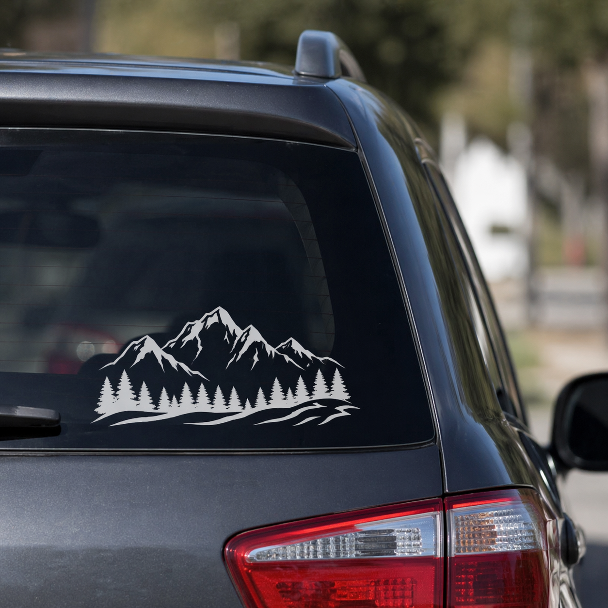 Car window with a mountain and forest decal on the back window