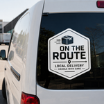 Hexagonal black and white 'On The Route Local Delivery' vinyl decal applied to the back window of a white commercial van.