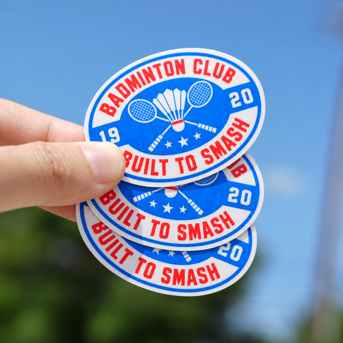 Oval vinyl stickers with a badminton club design held outdoors