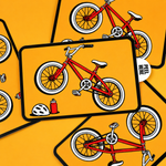 Custom peel tab stickers featuring a red bicycle illustration on a bright orange background.