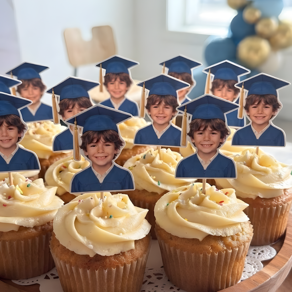 Cupcakes decorated with custom graduation photo face toppers featuring a boy in a blue cap and gown.