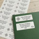 A sheet of personalized return address labels featuring a compass rose design, with one label applied to a dark green envelope.