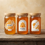 Three glass jars featuring custom honey labels with orange and white bee-themed designs, showcasing high-quality craftsmanship on professional vinyl material.