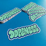 A stack of die-cut premium vinyl stickers featuring "Dopeness" in mint green bubble graffiti letters with a thick blue border, displayed on a vibrant blue background.