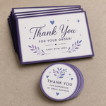 Purple and blue round thank you stickers displayed with matching thank you cards on a neutral background.