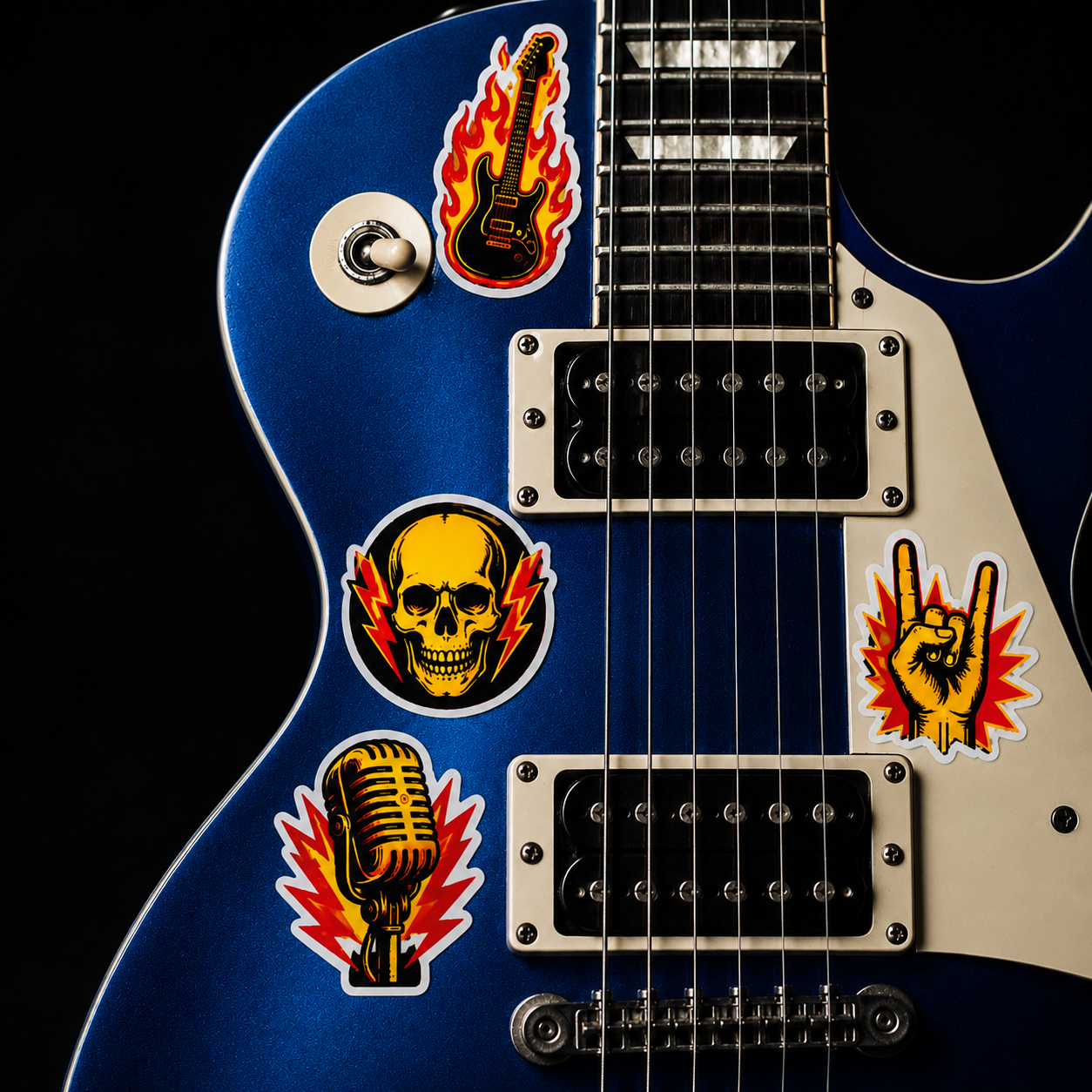 Custom band stickers featuring a skull, microphone, guitar, and rock hand sign on a blue electric guitar body.