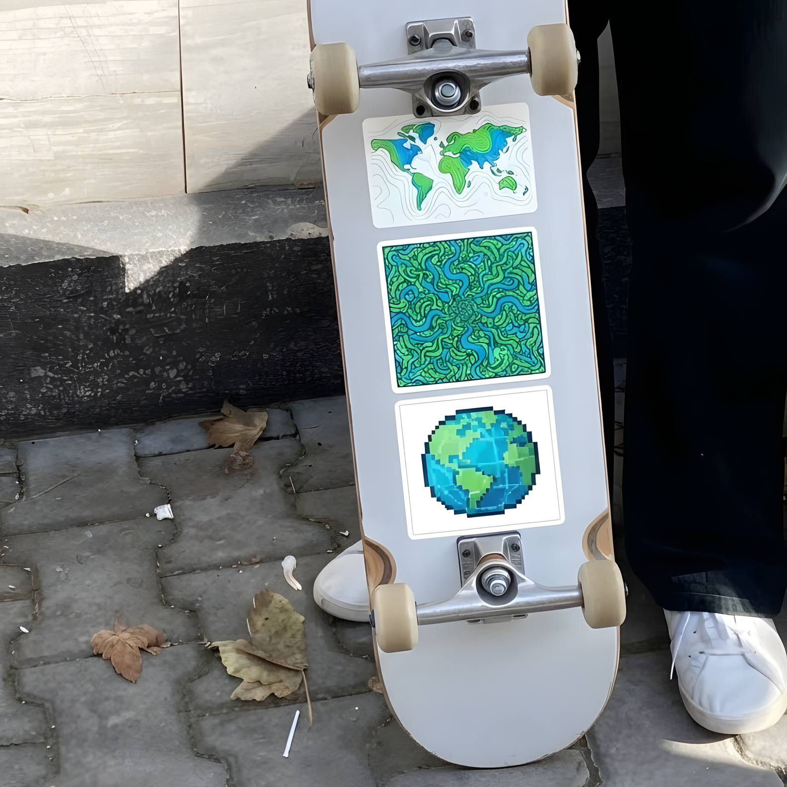 Skateboard deck decorated with custom nature, map, and planet earth stickers.