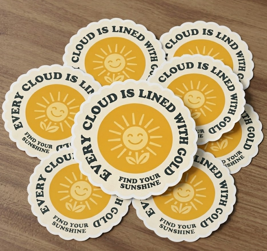 Stack of circular 2.5-inch vinyl stickers with "Every cloud is lined with gold" design, ideal for phone cases and small retail items.