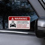Warning sticker for vehicle equipped with alarm system placed on a car window.